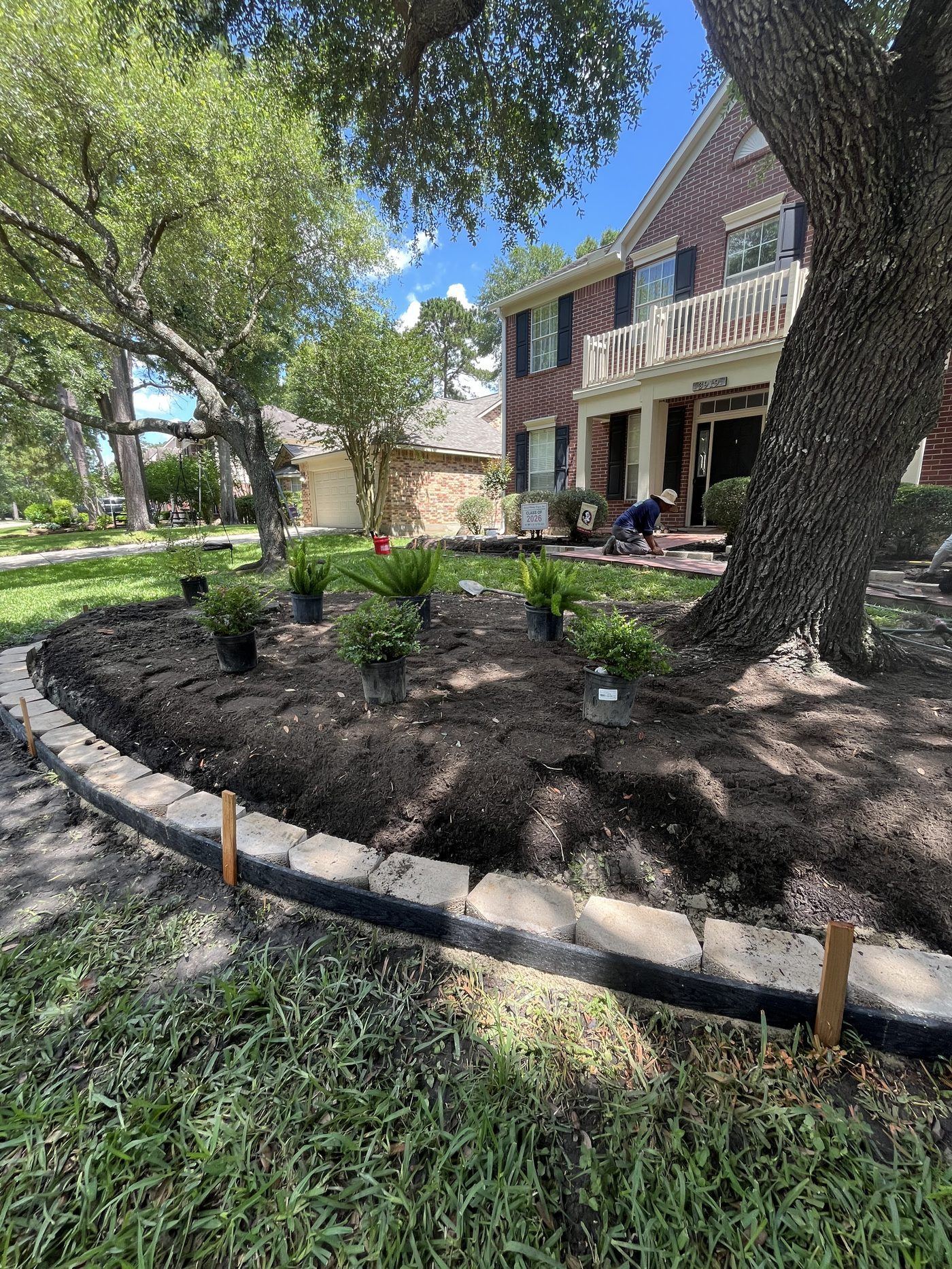 Large curved landscape bed with shrubs and flowers Houston TX